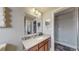 Modern bathroom with vanity, a large mirror, and tiled shower at 2881 W 65Th Ave, Denver, CO 80221