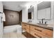 Modern bathroom with double vanity, sleek fixtures, and a stylish tiled shower at 9565 W 12Th Pl, Lakewood, CO 80215
