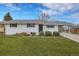Charming single-story home with a well-maintained lawn, white exterior, and covered parking at 9565 W 12Th Pl, Lakewood, CO 80215