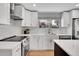 Updated kitchen features white cabinets, stainless steel appliances, and a stylish backsplash and countertops at 9565 W 12Th Pl, Lakewood, CO 80215