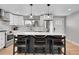 Modern kitchen features white cabinets, stainless steel appliances, quartz countertops, and an eat-in island at 9565 W 12Th Pl, Lakewood, CO 80215