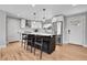 Bright kitchen with island seating, stainless appliances, white cabinetry, stylish pendant lighting, and light wood floors at 9565 W 12Th Pl, Lakewood, CO 80215