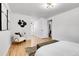 Bright bedroom with hardwood floors, modern lighting, and a view into the ensuite bathroom at 9565 W 12Th Pl, Lakewood, CO 80215