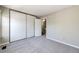 Bedroom featuring neutral walls, carpet, large closet doors, and doorway to hallway at 8231 S Fillmore Way, Centennial, CO 80122