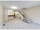 A cozy living room features modern carpeting and a staircase, with an adjacent breakfast bar and white cabinetry at 8231 S Fillmore Way, Centennial, CO 80122