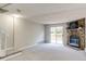Bright living room with plush carpet, stone fireplace, and sliding glass doors to the backyard at 8231 S Fillmore Way, Centennial, CO 80122
