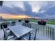 Spacious back deck with outdoor seating overlooking a golf course under a colorful sunset sky at 16701 Buffalo Run Dr, Commerce City, CO 80022