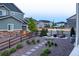 Inviting backyard featuring a fire pit, putting green, and professionally landscaped grounds at 16701 Buffalo Run Dr, Commerce City, CO 80022