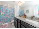 Bright bathroom with double vanity featuring granite counters and a colorful shower curtain at 16701 Buffalo Run Dr, Commerce City, CO 80022