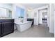 Beautiful bathroom with a free-standing tub, black cabinets, and great natural light at 16701 Buffalo Run Dr, Commerce City, CO 80022