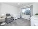 Cozy Bedroom with soft gray decor, a comfortable glider, and a white crib by a sunlit window at 16701 Buffalo Run Dr, Commerce City, CO 80022
