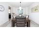 Dining area with a large table, modern chandelier, and view into the adjacent kitchen at 16701 Buffalo Run Dr, Commerce City, CO 80022