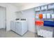 Well-organized laundry room with washer, dryer, shelving and tile floor at 16701 Buffalo Run Dr, Commerce City, CO 80022