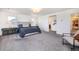 Bright main bedroom featuring a large bed, gray carpet, and an entrance to the primary bathroom and walk-in closet at 16701 Buffalo Run Dr, Commerce City, CO 80022