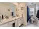Bright bathroom featuring double sink vanity with marble countertop and a tiled shower-tub at 39286 Hart Cir, Elizabeth, CO 80107