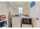 Convenient laundry room with Whirlpool washer/dryer set and overhead shelving, next to a window at 39286 Hart Cir, Elizabeth, CO 80107