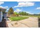 Charming front yard with lush green lawn, mature trees, and a concrete driveway leading to a lovely house at 309 W Oak St, Lafayette, CO 80026