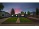 Charming home at dusk with a lush lawn, sidewalk and manicured landscape at 309 W Oak St, Lafayette, CO 80026