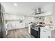 Bright kitchen featuring white cabinets, stainless steel appliances and a brick fireplace at 309 W Oak St, Lafayette, CO 80026