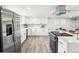 Open kitchen showcasing stainless steel refrigerator and stove, white cabinets and hardwood floors at 309 W Oak St, Lafayette, CO 80026