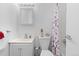 A clean and bright bathroom featuring a floral shower curtain at 5562 Anaheim Way, Denver, CO 80239