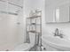 Functional bathroom featuring white tiled shower, vanity and decorative shelving at 5562 Anaheim Way, Denver, CO 80239