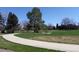 Scenic park view with walking path, lush green grass, and mature trees at 5562 Anaheim Way, Denver, CO 80239