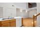 Galley kitchen shows dishwasher and bright countertops leading to open-concept dining and living space with hardwood floors at 2846 W Centennial Dr # E, Littleton, CO 80123