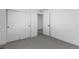 A bedroom featuring a closet with sliding doors, a white door, and neutral gray carpeting at 14245 Currant St, Broomfield, CO 80020