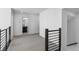 A hallway with carpet, wooden railing, and a view of a bathroom with black vanity at 14245 Currant St, Broomfield, CO 80020