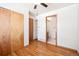 Bright bedroom featuring hardwood floors, a ceiling fan, and an adjacent bathroom at 4656 S Dillon Ct # D, Aurora, CO 80015