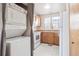 Well-lit kitchen with wooden cabinets, white appliances, and a convenient stacked washer and dryer unit at 4656 S Dillon Ct # D, Aurora, CO 80015