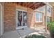 Outdoor patio area with brick facade, sliding glass door, and a covered ceiling at 4656 S Dillon Ct # D, Aurora, CO 80015
