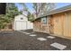 Well maintained backyard with stone walkway connecting the buildings to the back of the property at 7114 S Costilla St, Littleton, CO 80120
