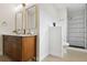 Bright bathroom with sleek modern fixtures, wood vanity, shower with black tile at 7114 S Costilla St, Littleton, CO 80120