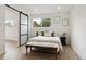 Bright bedroom with white walls, sliding door, light wood floors, and decorative seating at 7114 S Costilla St, Littleton, CO 80120