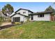Charming two-story home with modern black garage door and nicely landscaped front yard at 7114 S Costilla St, Littleton, CO 80120