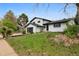 Beautifully renovated two-story home features landscaped front yard and modern black garage door at 7114 S Costilla St, Littleton, CO 80120