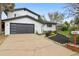 Stylish white home featuring a black garage door, manicured front yard with modern curb appeal at 7114 S Costilla St, Littleton, CO 80120