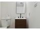Modern half-bathroom featuring a floating vanity, sleek mirror, and neutral walls at 7114 S Costilla St, Littleton, CO 80120