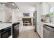 Modern kitchen features stainless steel appliances and an open layout to the living area and stairs at 7114 S Costilla St, Littleton, CO 80120