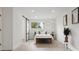 Bright main bedroom featuring a sliding barn door closet, modern decor, and plenty of natural light at 7114 S Costilla St, Littleton, CO 80120