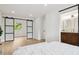 Bright main bedroom featuring a sliding barn door, ample natural light, and en suite bathroom at 7114 S Costilla St, Littleton, CO 80120