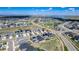 Wide aerial shot of a suburban neighborhood featuring similar-style homes, green spaces, parks, roads, and nearby lake at 7202 S Valleyhead Ct, Aurora, CO 80016