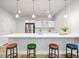 This kitchen bar features modern pendant lights and colorful barstools, creating a vibrant and inviting space at 7202 S Valleyhead Ct, Aurora, CO 80016