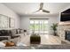 Bright living area with a stone fireplace, large windows, and modern ceiling fan at 7202 S Valleyhead Ct, Aurora, CO 80016