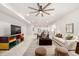 Bright living room featuring modern decor, a ceiling fan, and an open concept design leading to the kitchen at 7202 S Valleyhead Ct, Aurora, CO 80016