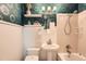 Charming bathroom with patterned wallpaper, updated vanity and tub shower at 1465 S Urban Way, Lakewood, CO 80228