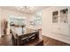 Dining area with a dark wood table, modern light fixture, and a view of the adjacent living room and kitchen at 1465 S Urban Way, Lakewood, CO 80228