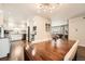 Open dining and kitchen area featuring dark wood floors, white cabinets, stainless steel appliances, and natural light at 1465 S Urban Way, Lakewood, CO 80228